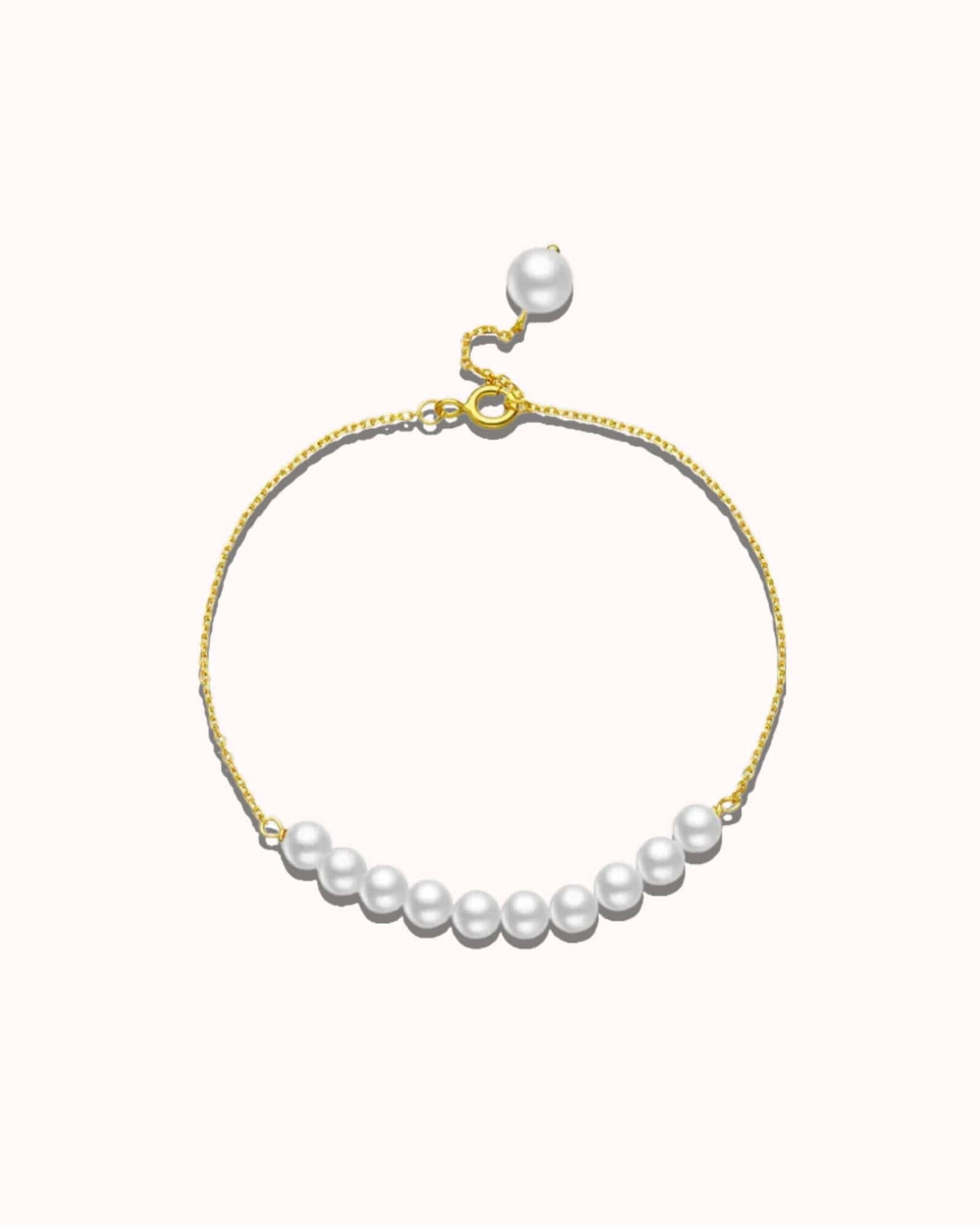 Pearl bracelet with gold clasp on a white background