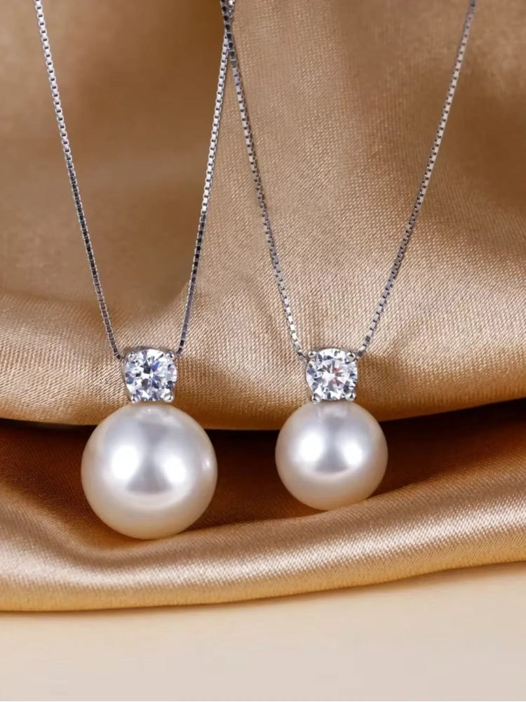Elegant Maris Pearl Necklace featuring AAA-grade pearls and zirconia pendant on a luxurious satin background.