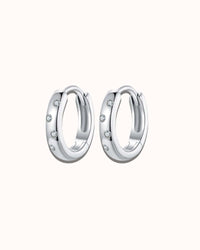 Pair of silver hoop earrings with small stones on a white background