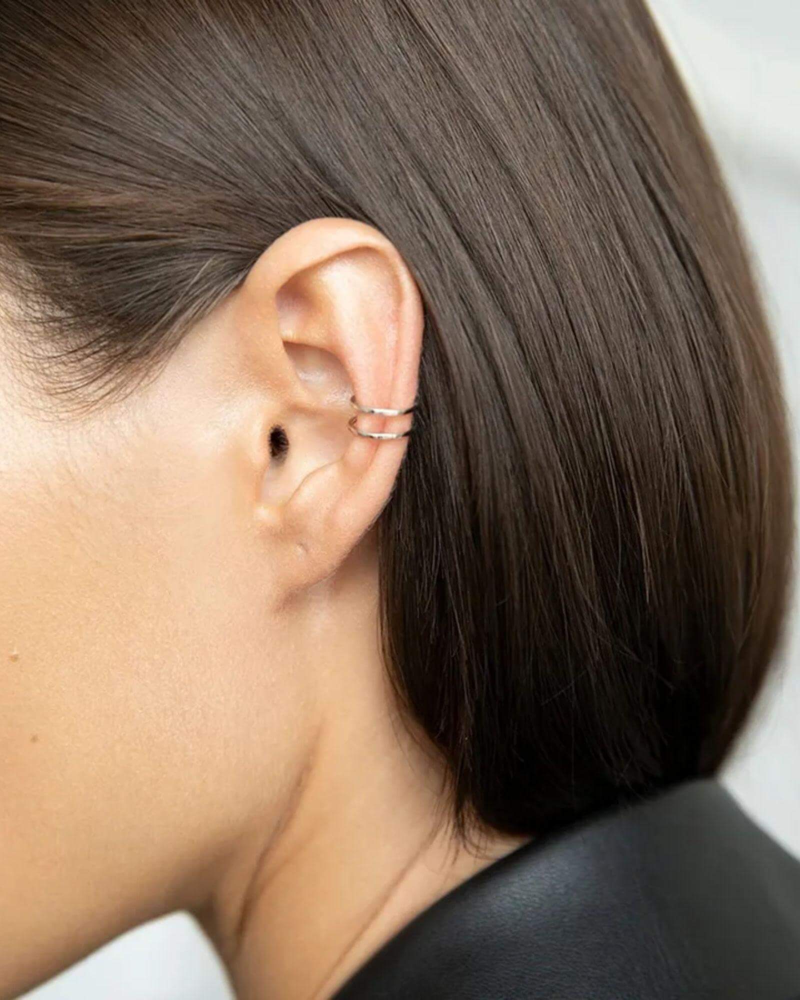 Close-up of double ear cuff jewellery in silver worn on a woman's ear, showcasing its elegant design.