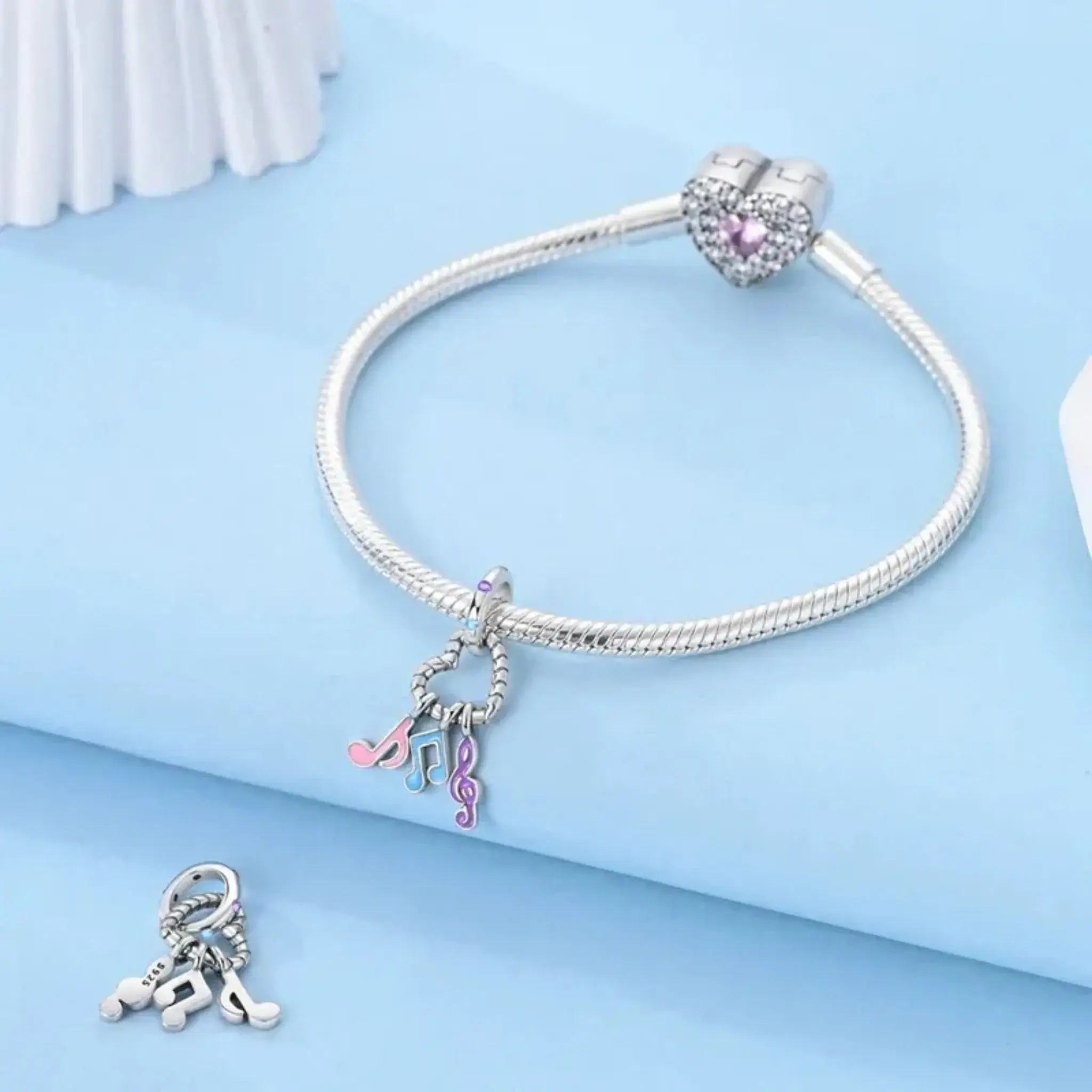 Silver bracelet with charms on a light blue background