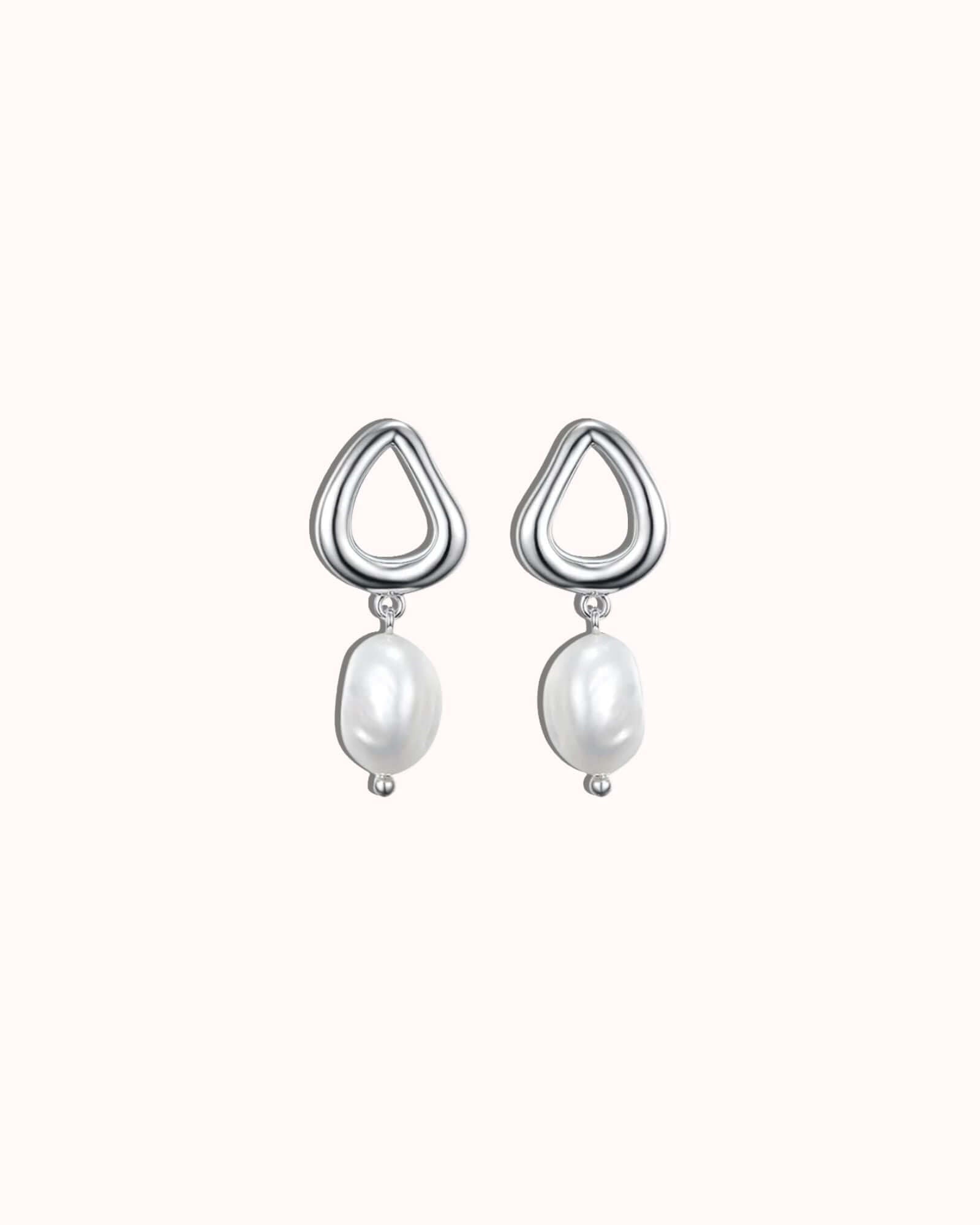 Pair of silver earrings with pearl drops on a white background