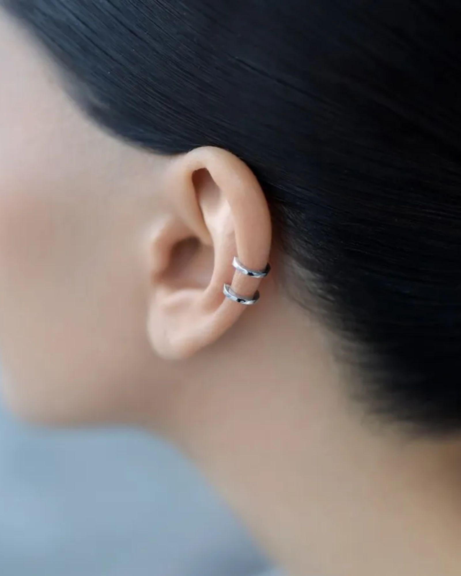 Double band ear cuff showcased in silver on an elegant ear, highlighting modern minimalist design.