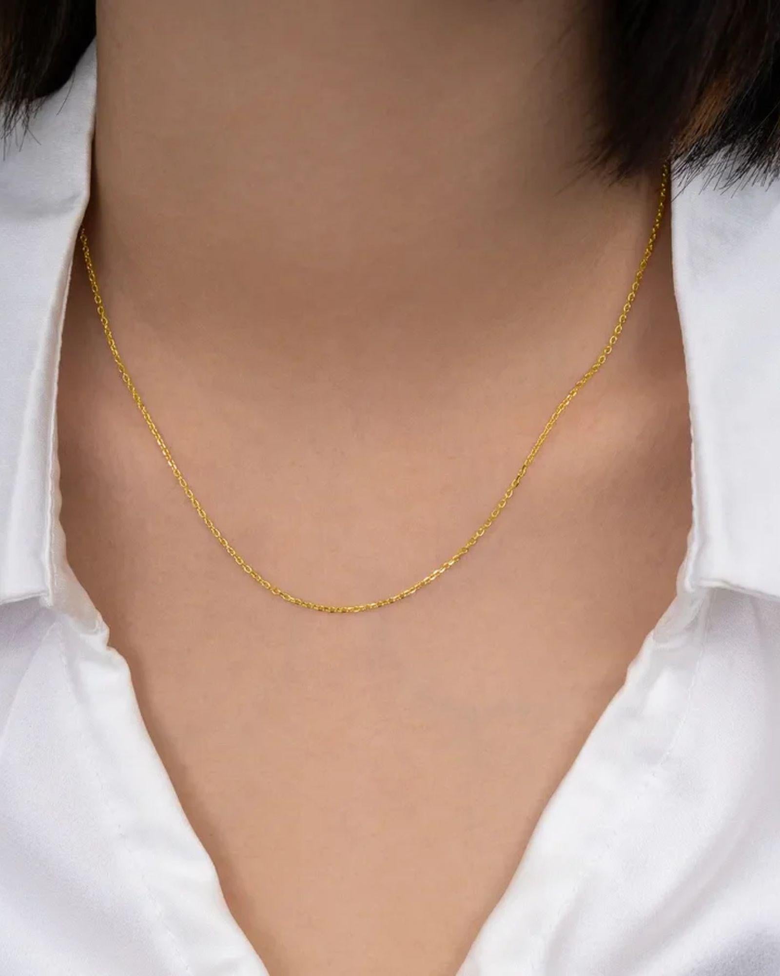 simple gold cable chain 16 inch worn on a person with a white shirt.