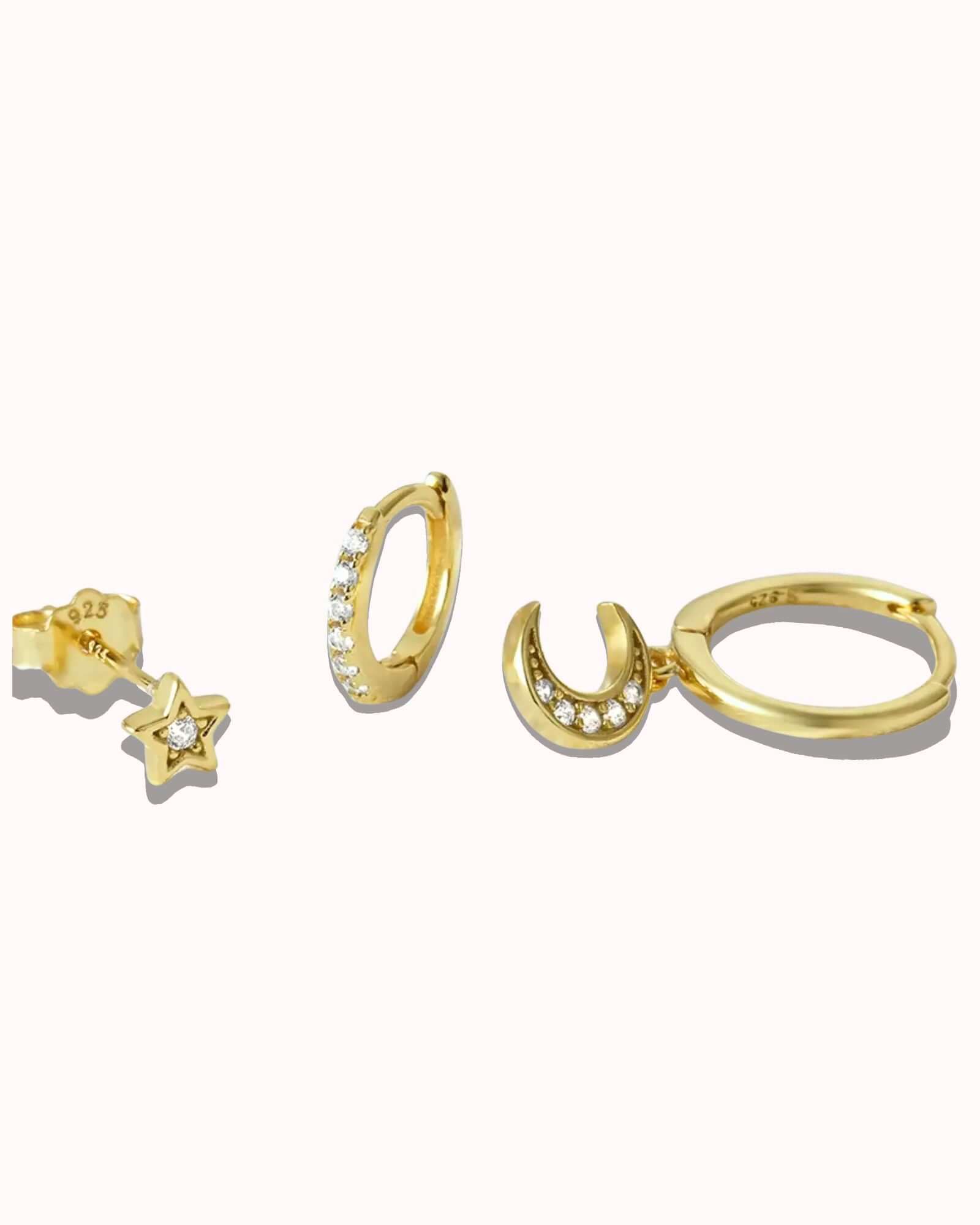 Three piece earring set featuring sterling silver star, zircon hoop, and crescent moon designs in gold plating.