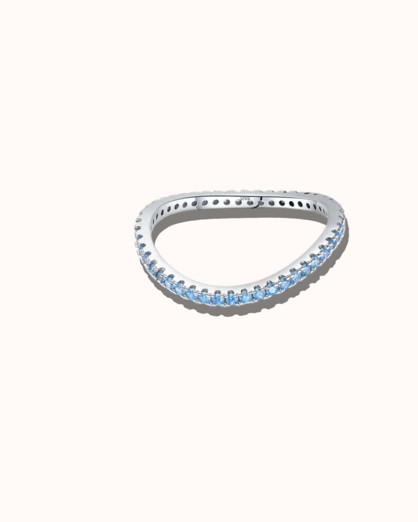 Silver ring with blue gemstones on a white background