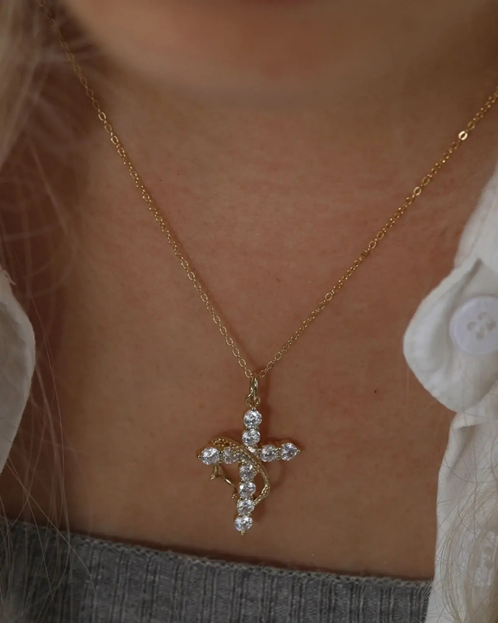 Elegant gold Faith pendant necklace with rhinestones, featuring a cross and crown design on a chain.