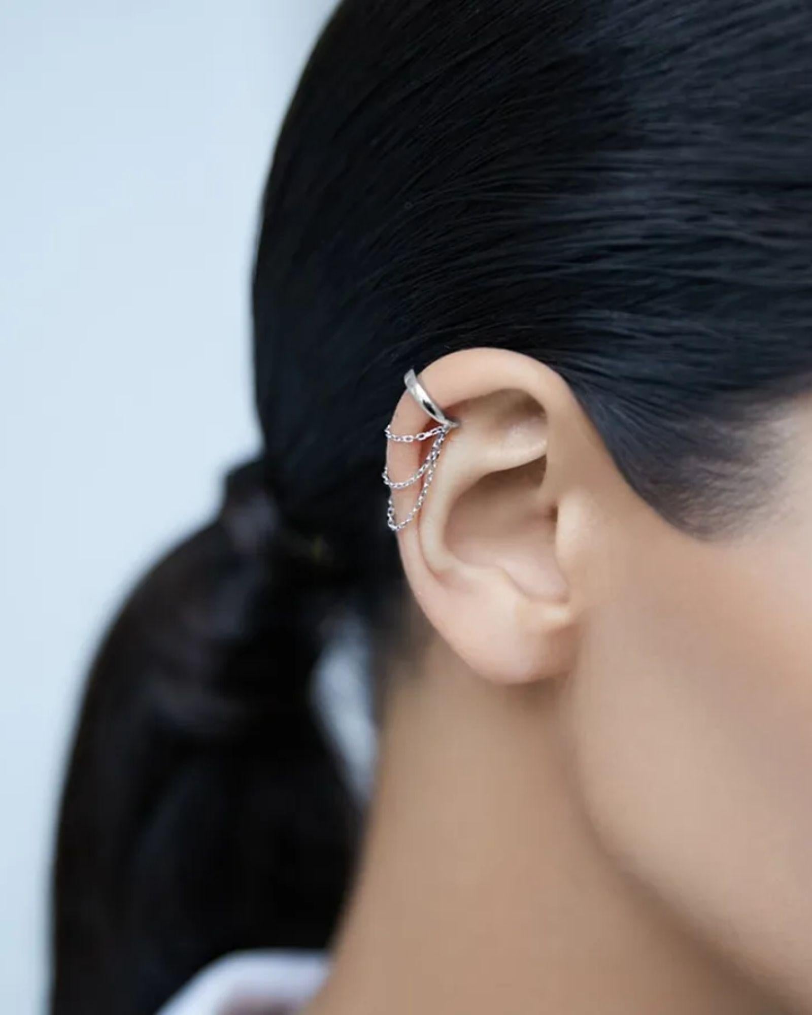 Three layer Chain Ear Cuff in silver worn on the ear, showcasing delicate chains and a trendy design.