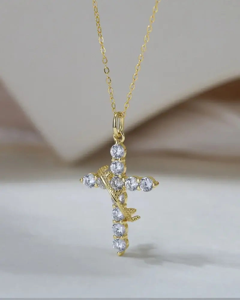 Elegant gold cross pendant necklace adorned with sparkling crystals, perfect for a stylish and meaningful accessory.