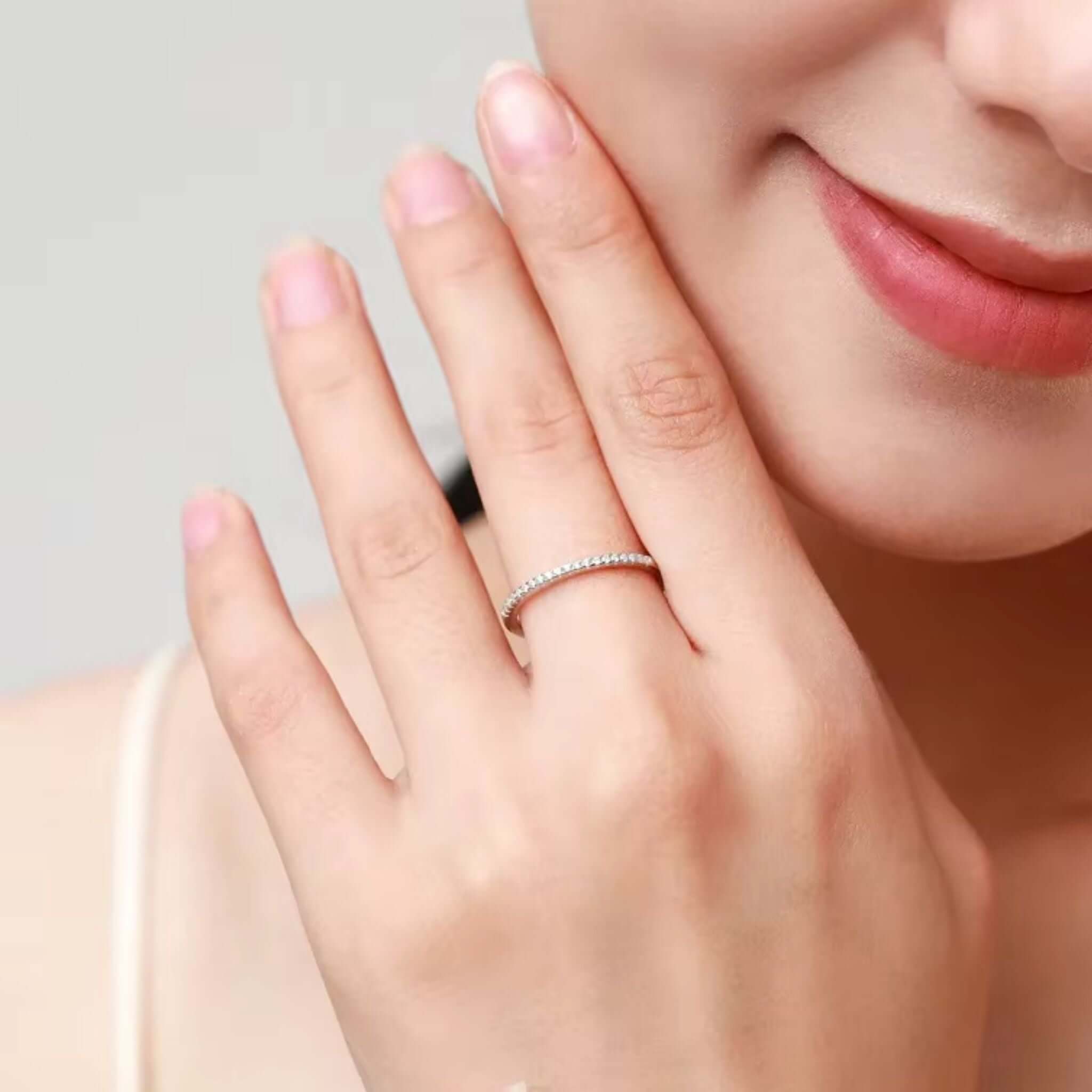 Woman wearing a Half Eternity Rose Gold Ring, showcasing its elegant design and sparkling bezel-set zircons.