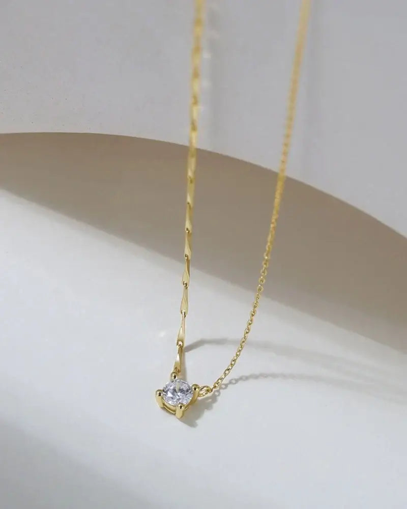 Elegant bling pendant necklace featuring a round cubic zirconia on a sleek 18k gold plated chain.