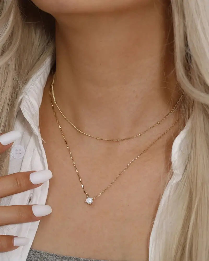 Bling pendant necklace featuring gold cable chains and zircon pendant, showcasing elegance and sophistication on a model.
