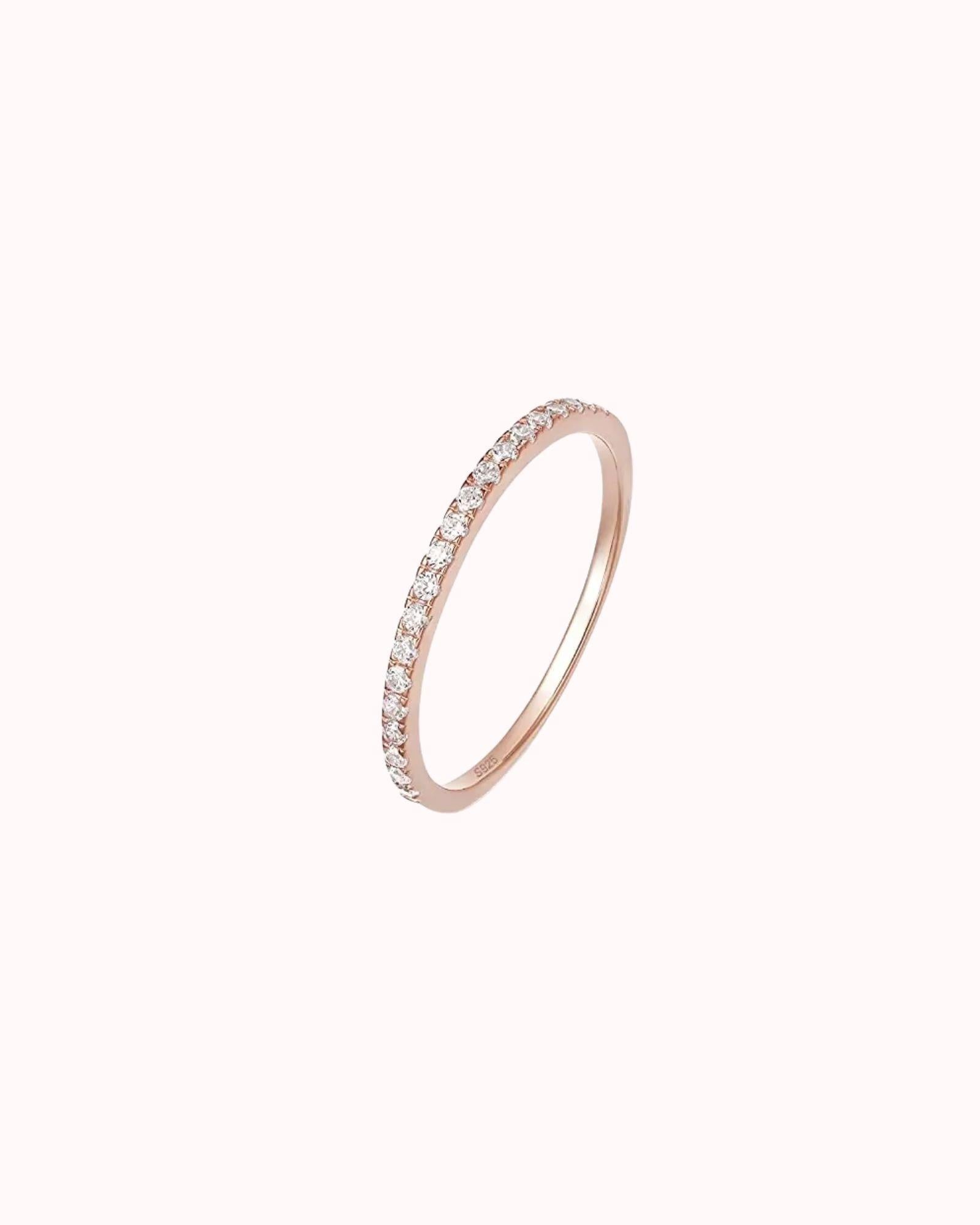 Half eternity rose gold ring with bezel-set zircons on a sleek 925 sterling silver band.
