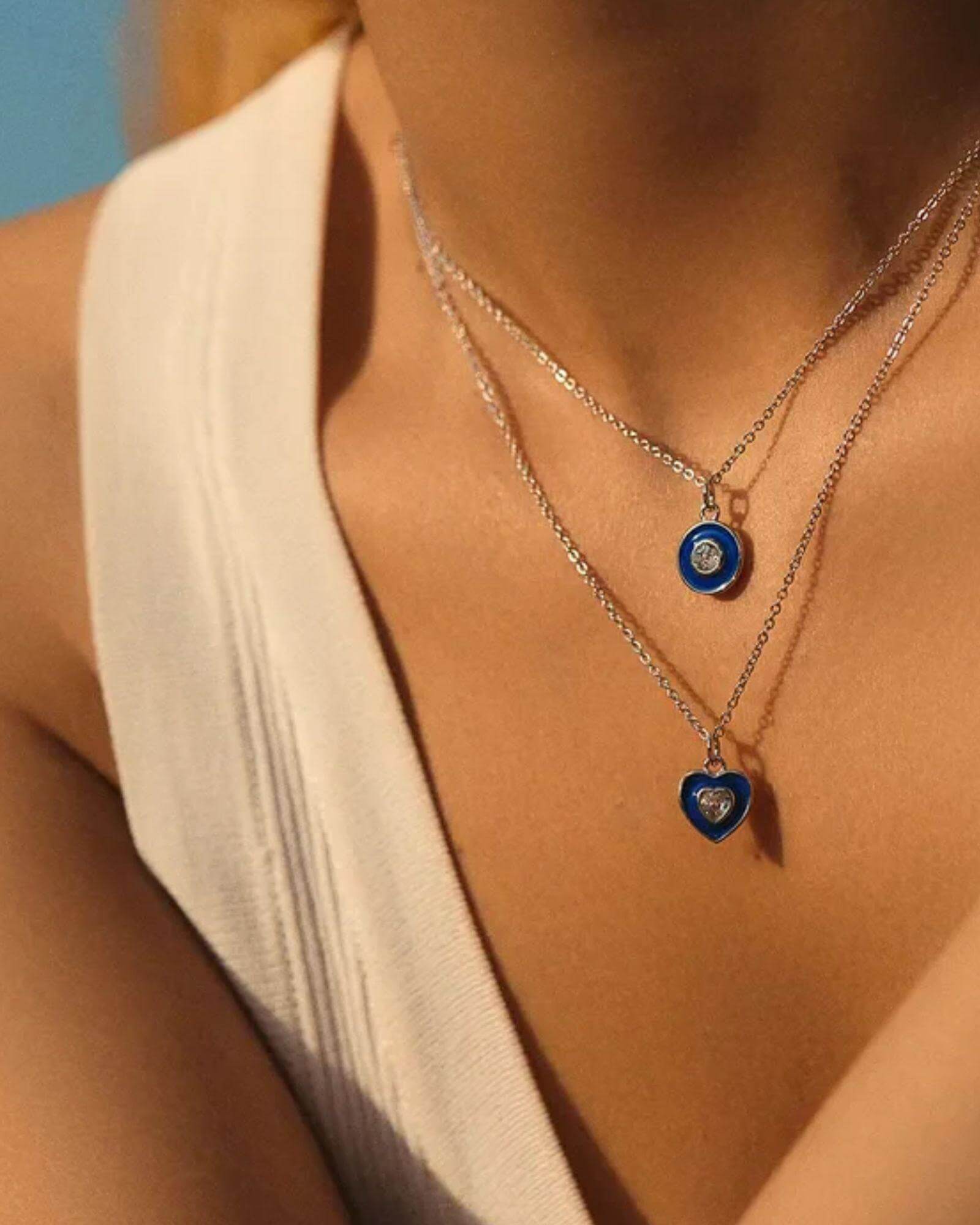 Heart Devil's Eye Pendant necklace displayed on a model, featuring blue accents and sterling silver chains.