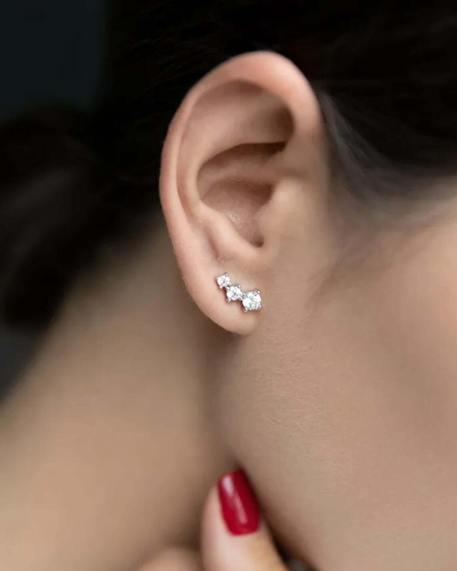 Elegant rhombus stud earrings in Silver showcased on a woman's ear.