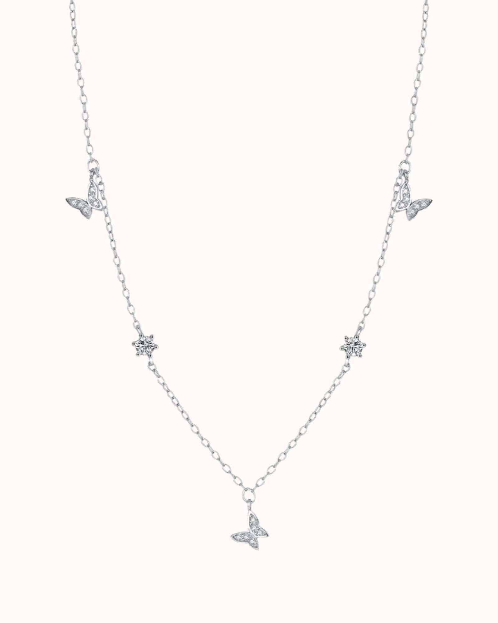 Silver necklace with butterfly pendants on a white background