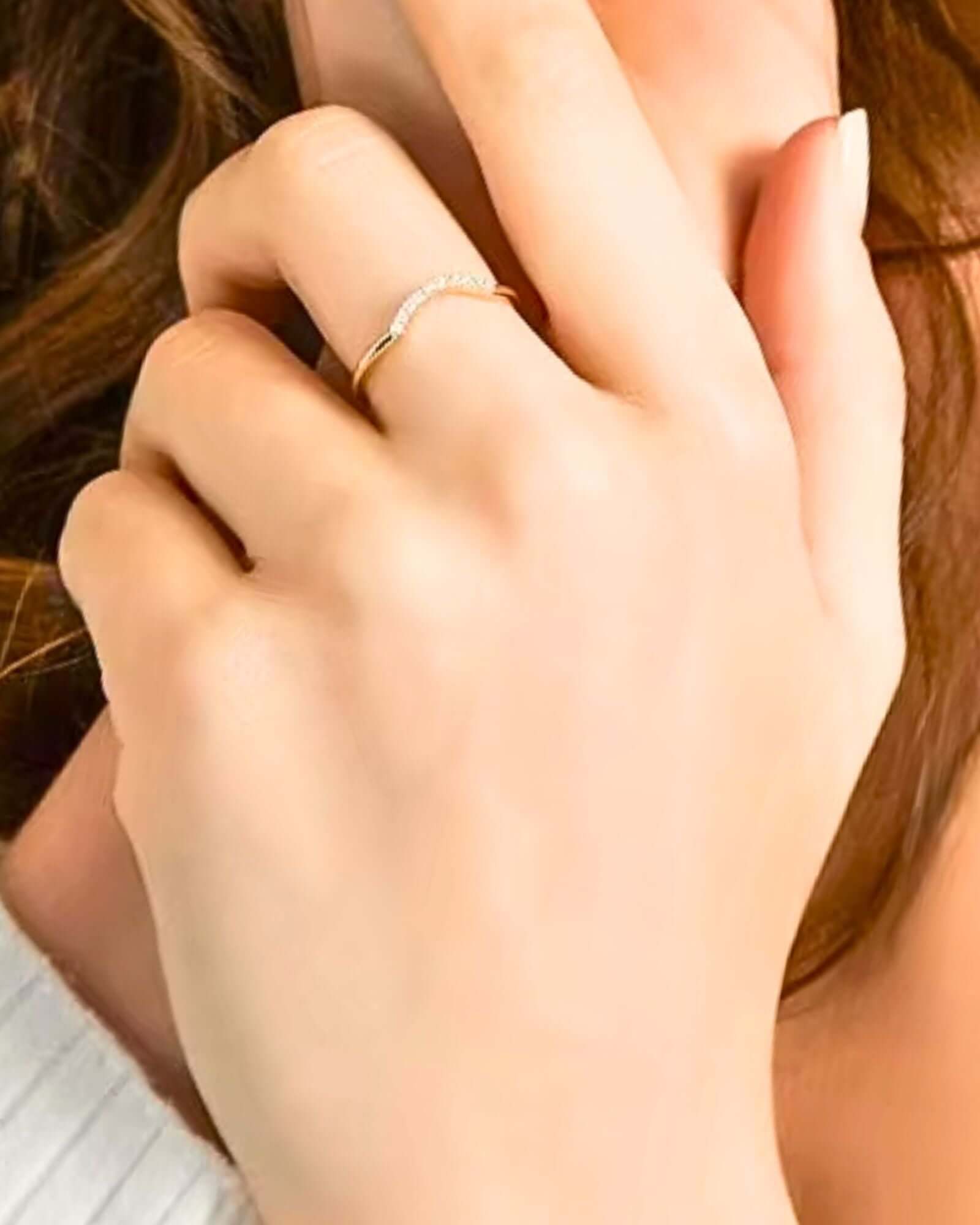 Close-up of a hand wearing a gold ring with a blurred background