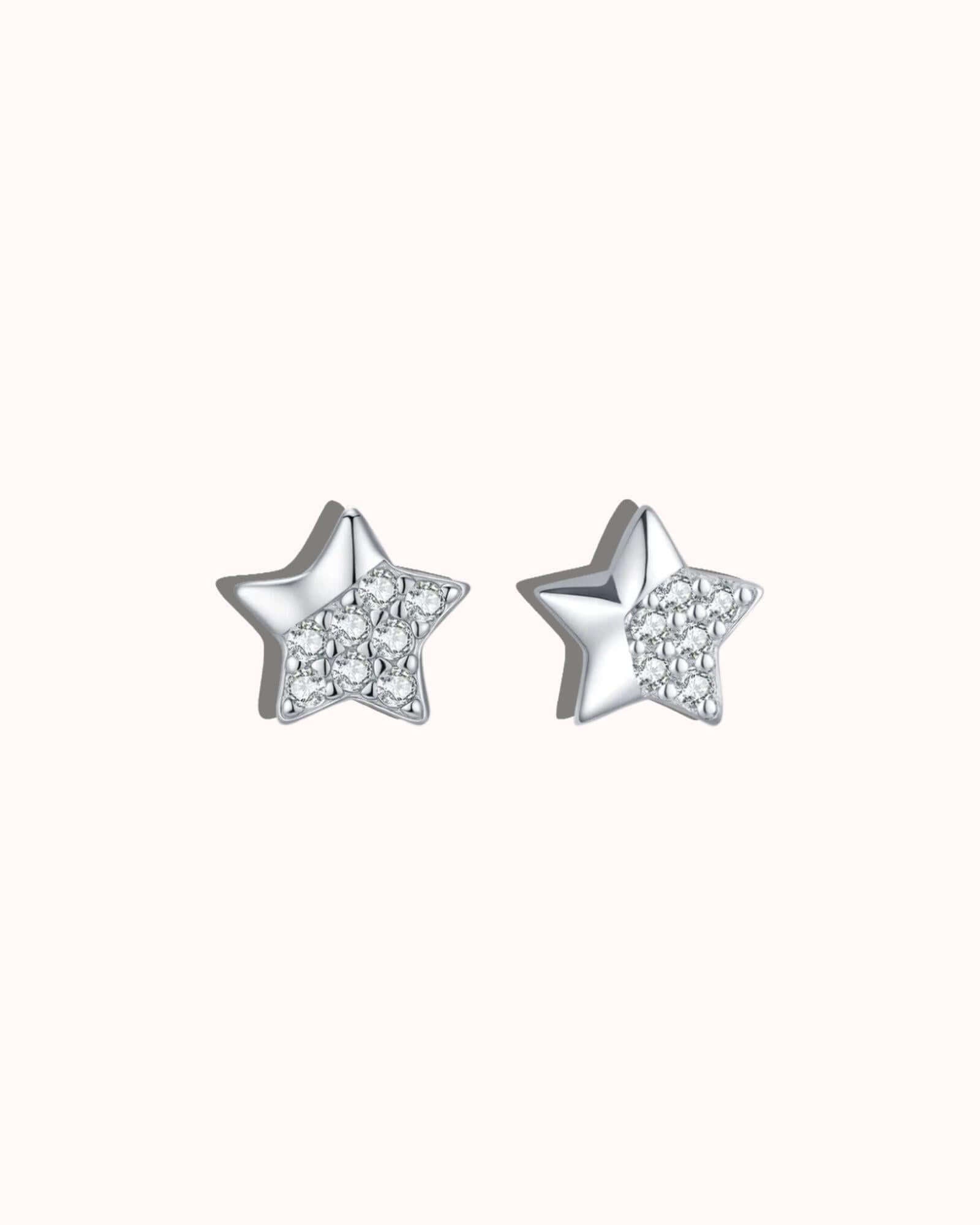 Star-shaped silver earrings with small diamonds on a white background