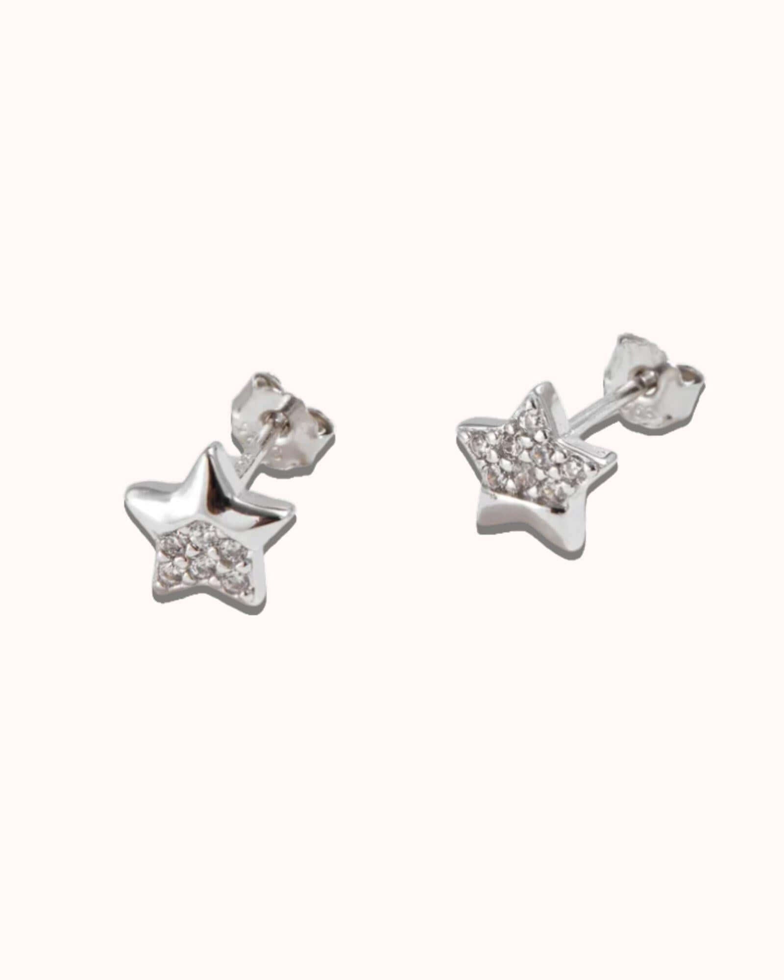 Star-shaped silver earrings with clear stones on a white background