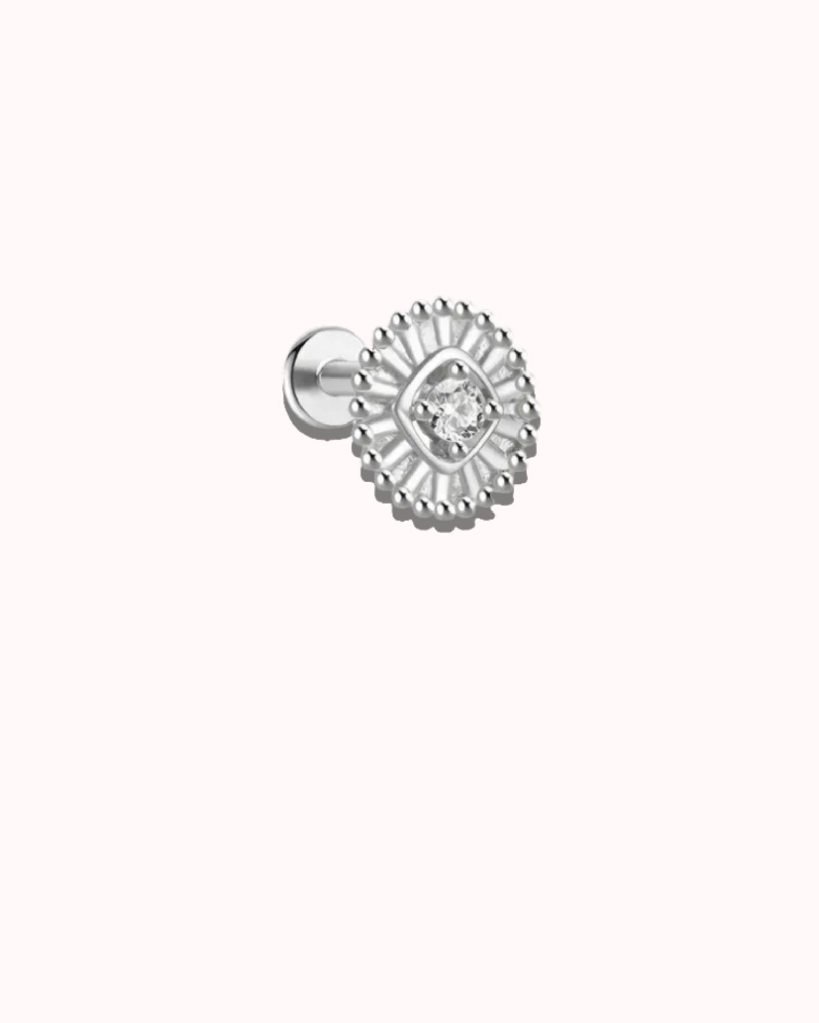 Silver earring with a clear gemstone on a white background