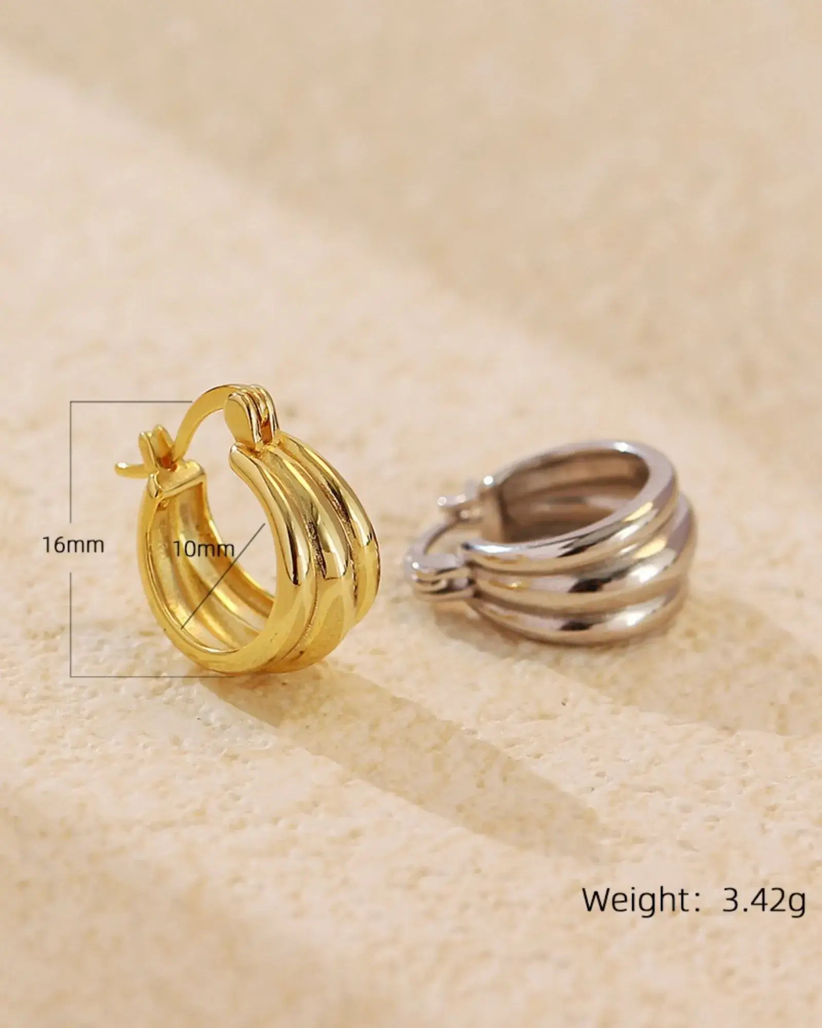 Aura Curve Hoop Earrings in gold and silver finishes, showcasing sleek, sculptural design with wave-like curves.