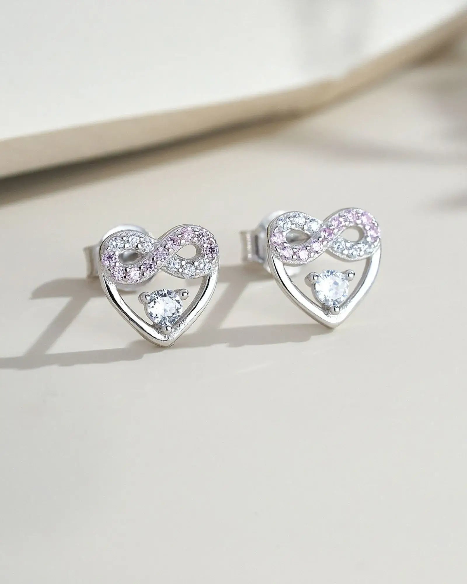 Eternal Blush Heart Ear Studs featuring a crystal and infinity symbol with pink and white stones in sterling silver.