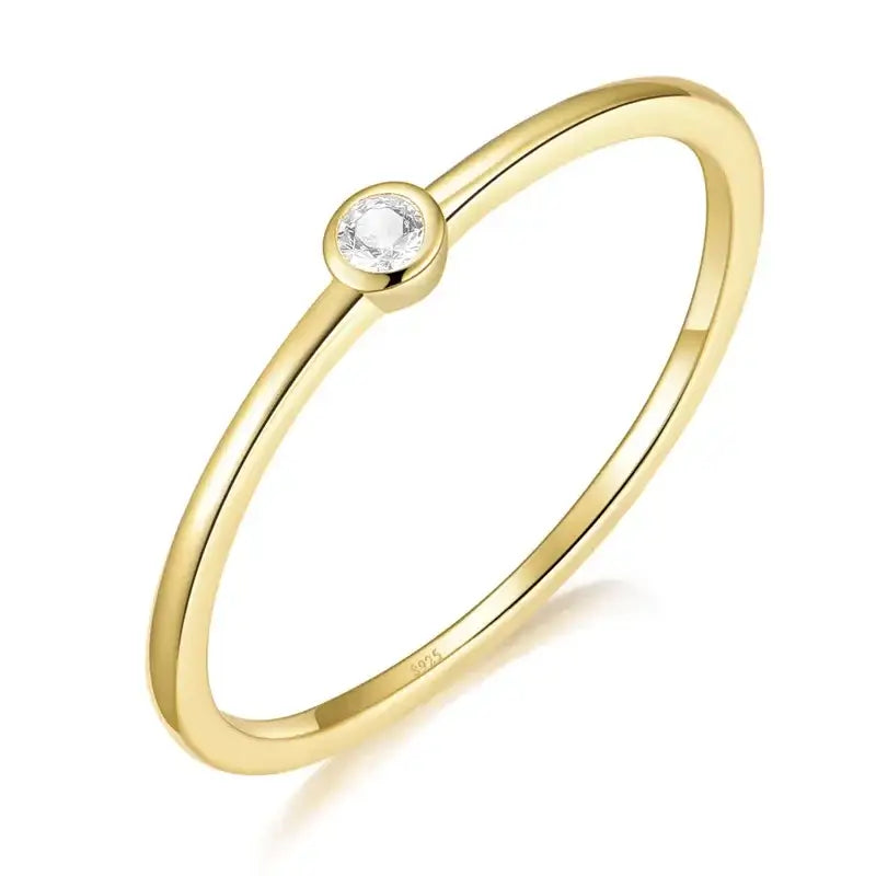 Elegant gold-plated sterling silver ring with round cubic zirconia bezel setting, part of the Golden Whisper collection.