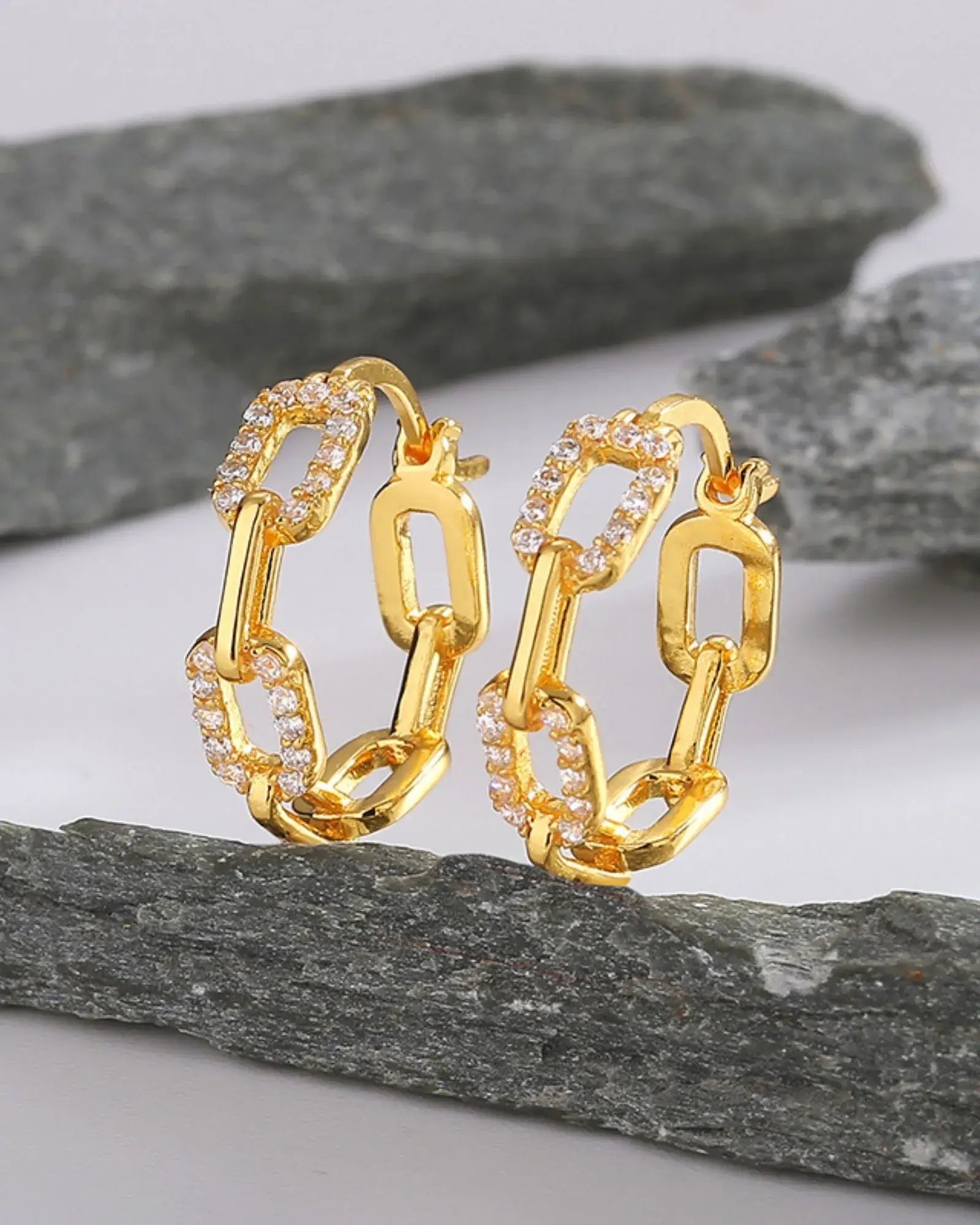 Hollow Chain Link Luxe Hoops featuring gold plating and AAA cubic zirconia accents on a stone background.
