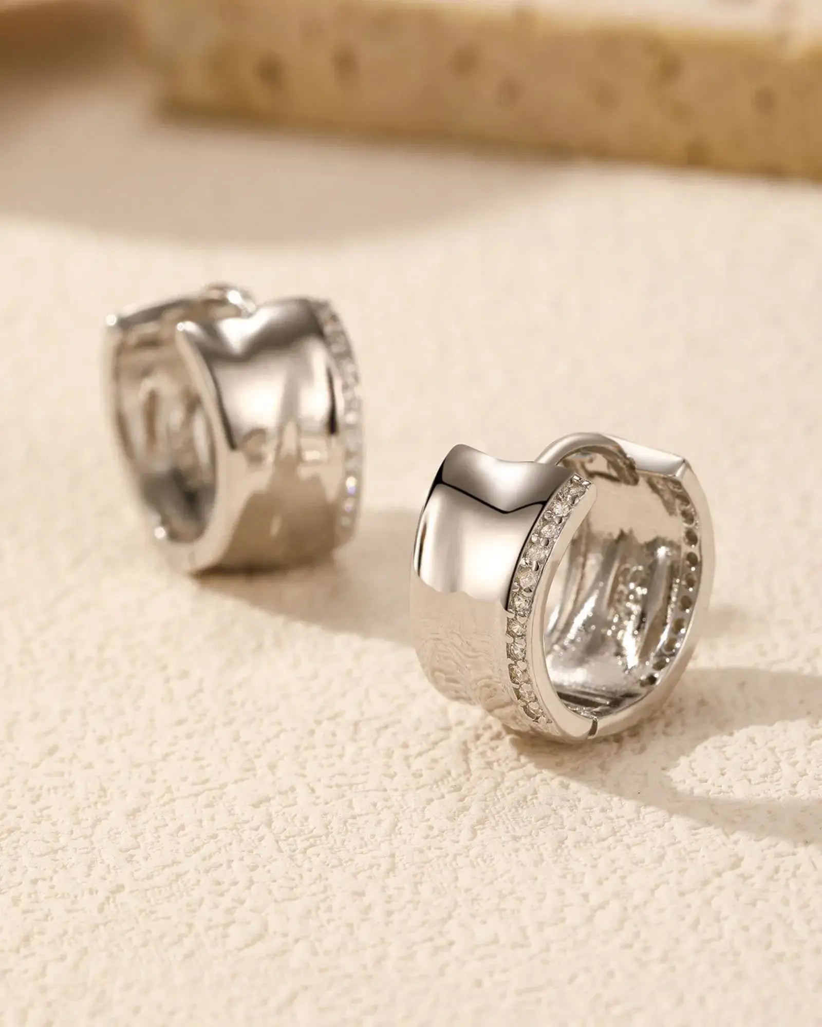 Irregular small zircon hoop earrings in 925 sterling silver with rhodium plating and pavé zirconia embellishments.