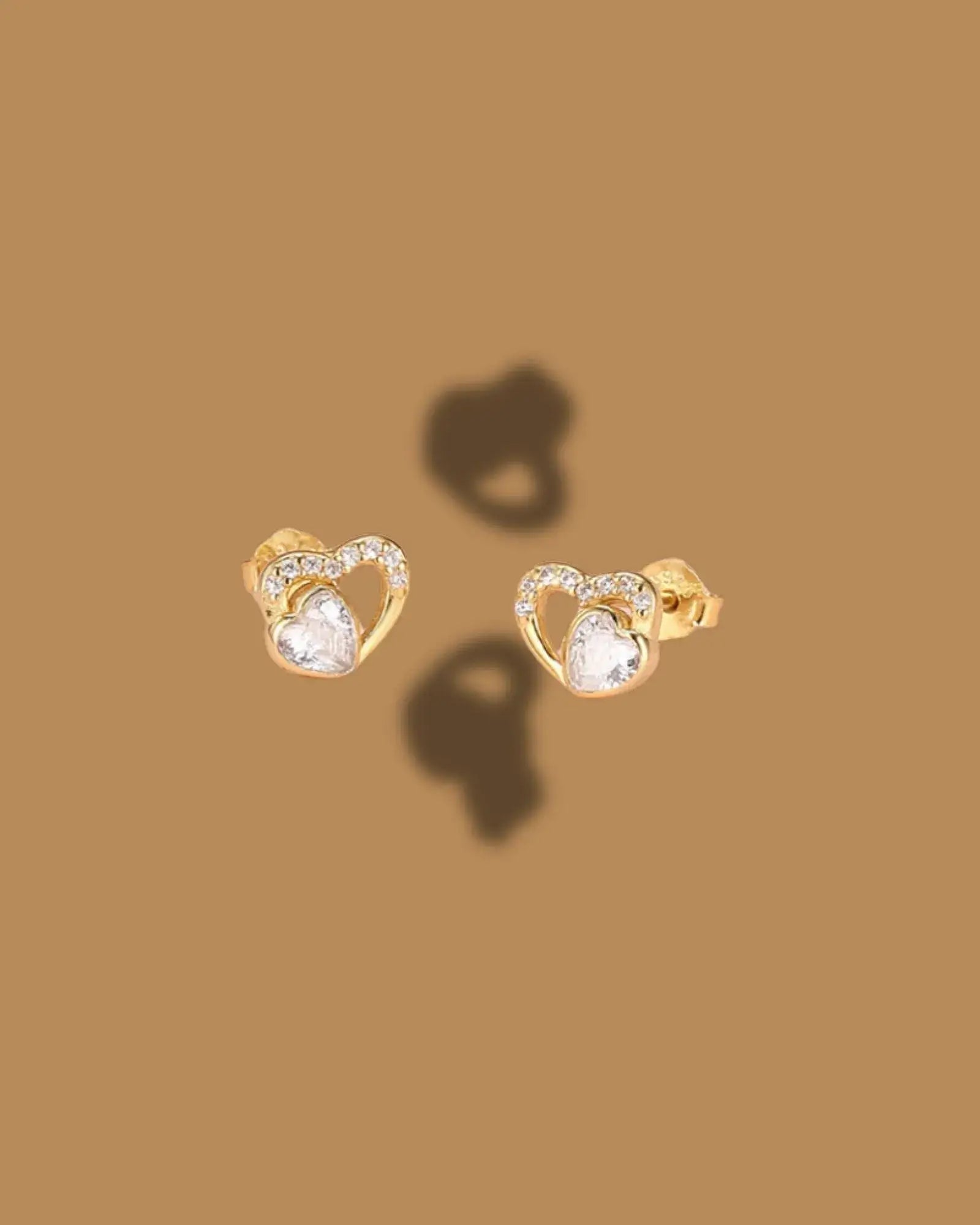 Love Glow Stud earrings in gold with heart design and shimmering stones, perfect for elegant evening wear.