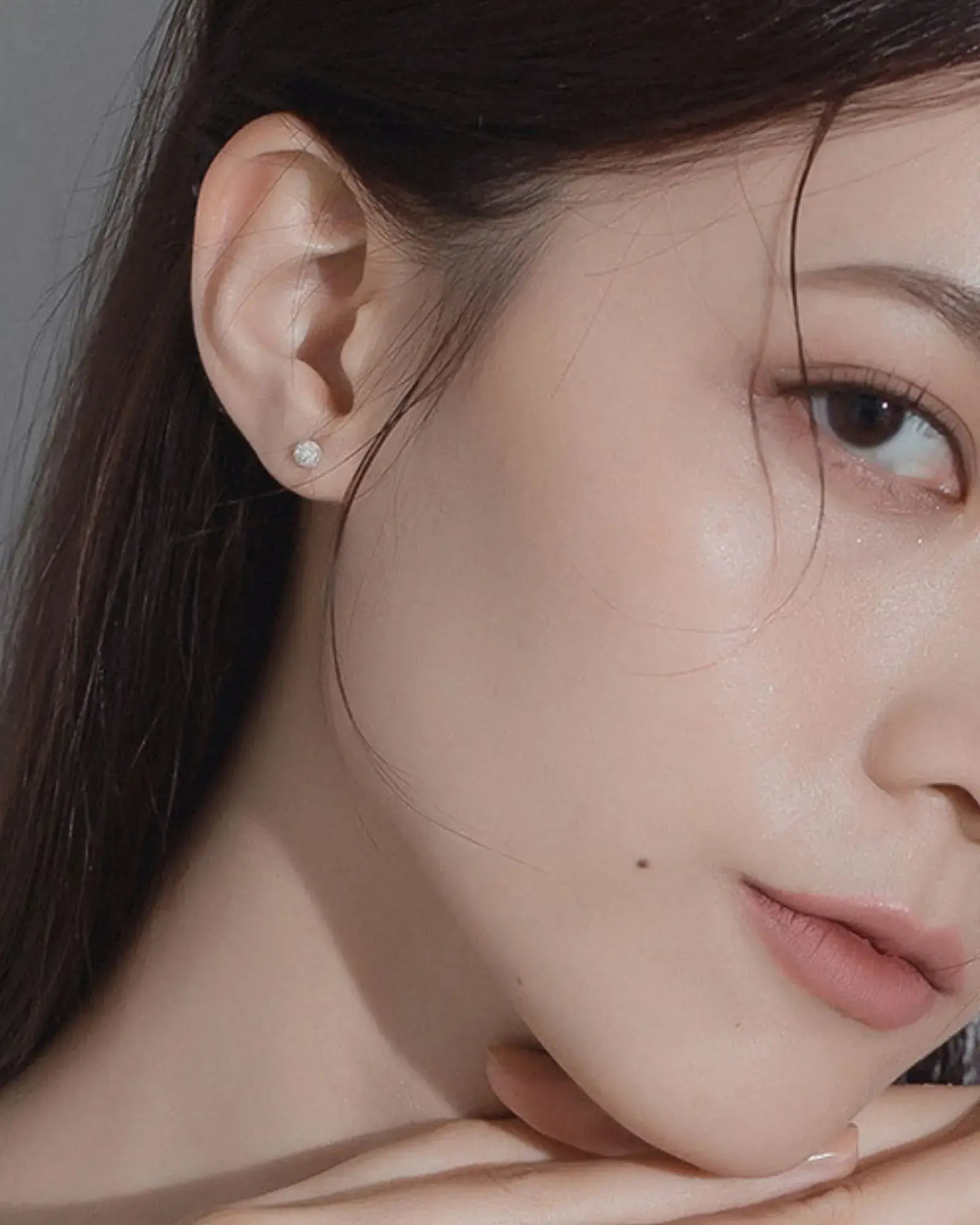 Close-up of a model wearing Luna Frost Ear Studs, showcasing their frosted crystal design and minimalist elegance.