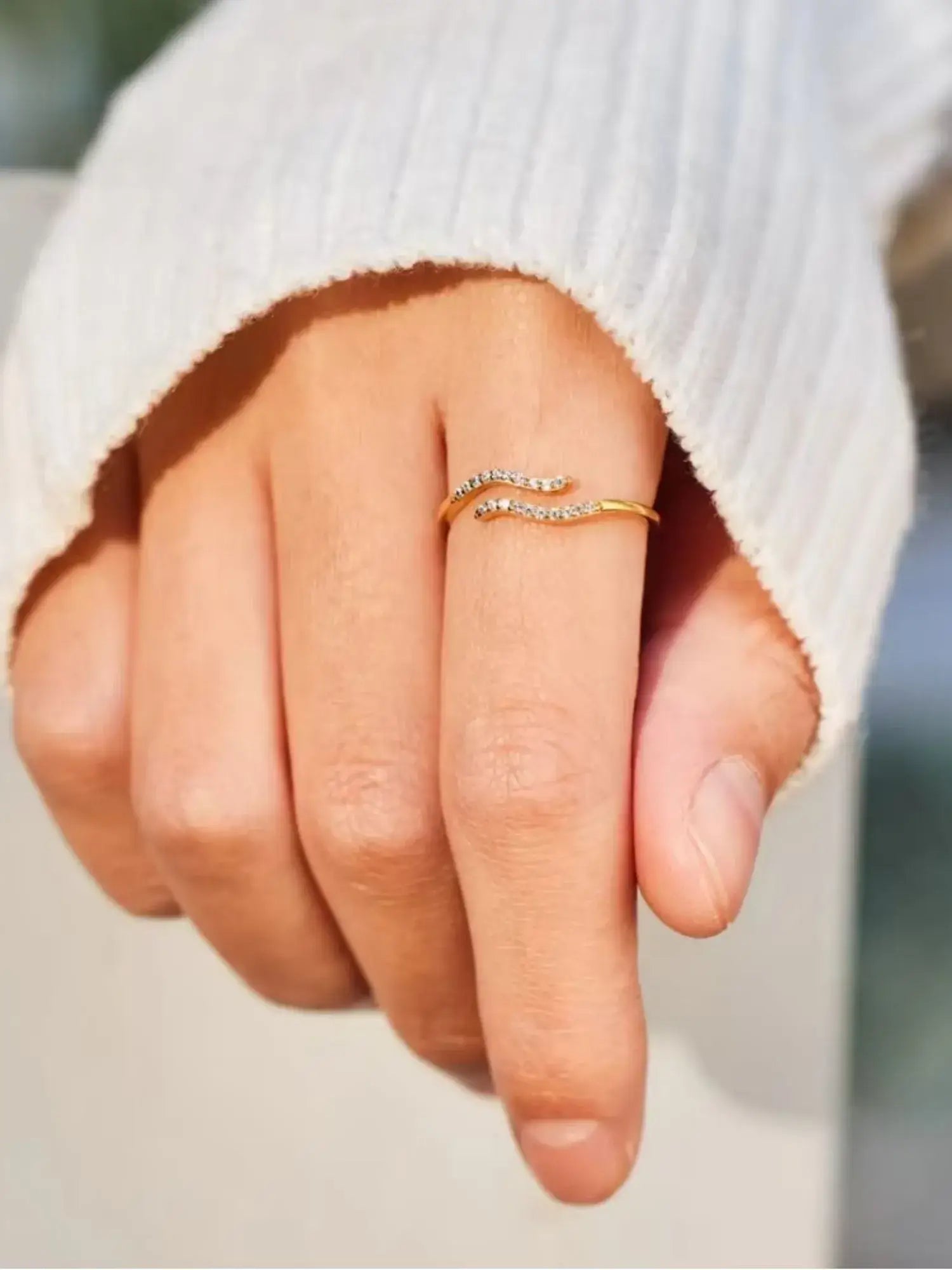 Minimalist Single Wave Ring in 18k gold with pavé-set stones, showcased on a hand wearing a cozy sweater.