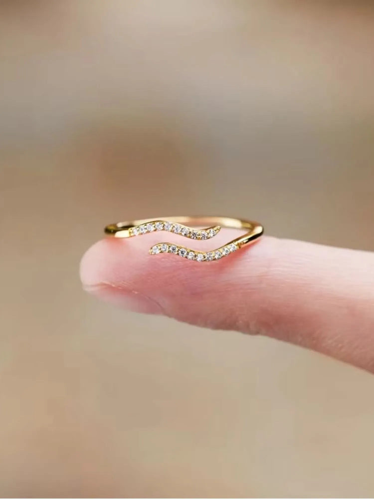 Minimalist Single Wave Ring in 18k gold with pavé-set stones, elegantly resting on a fingertip.