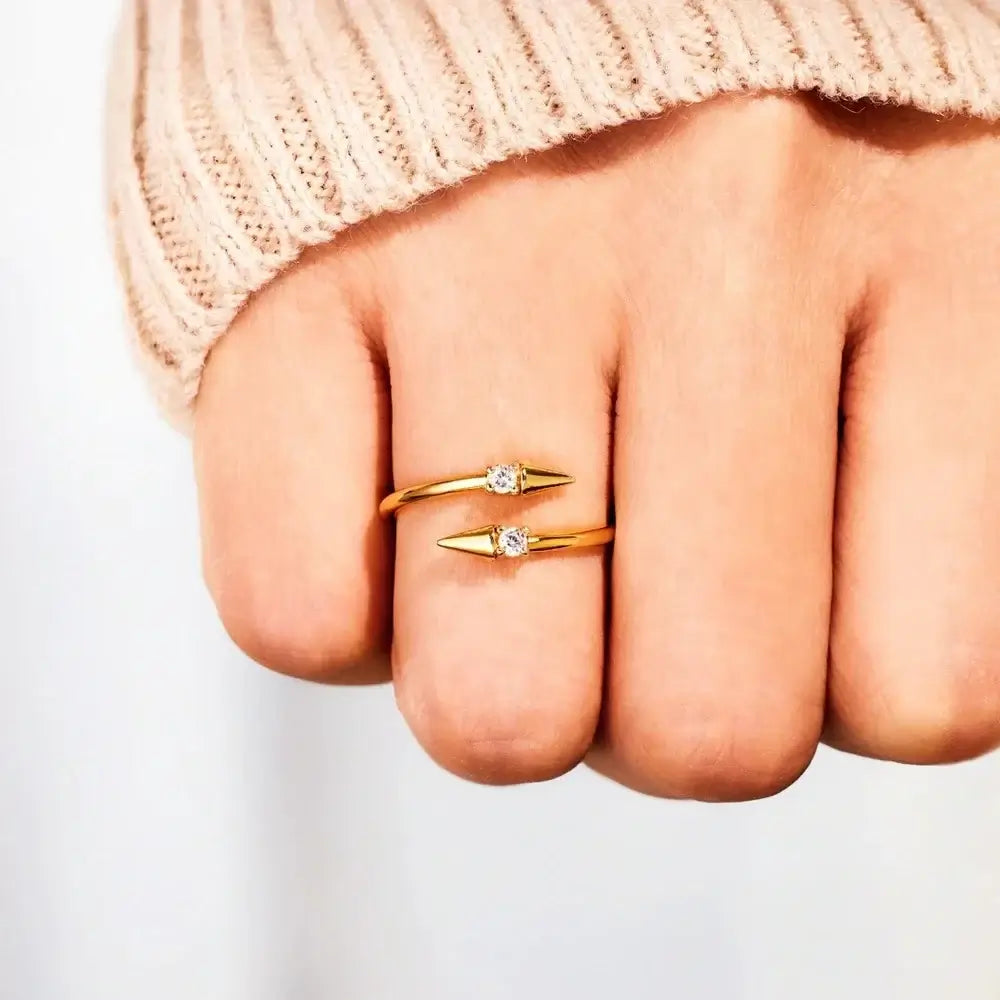 Close-up of a hand wearing a gold Open Arrow Ring with cubic zirconia details, perfect for stylish stacking.