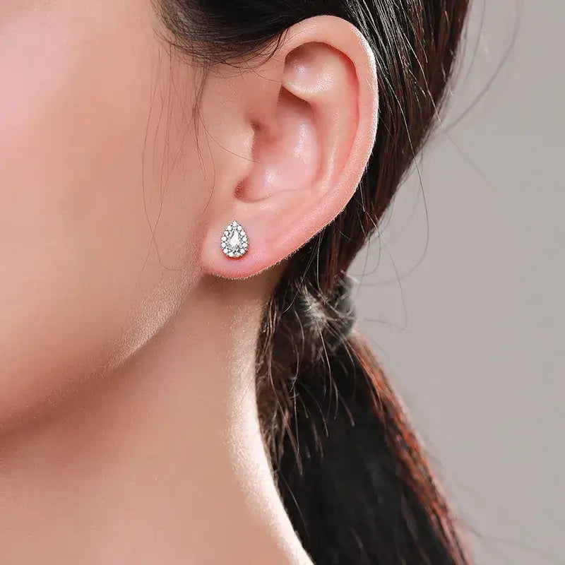 Close-up of sterling silver water droplets ear studs worn on a female ear, showcasing elegant zircon inlay.