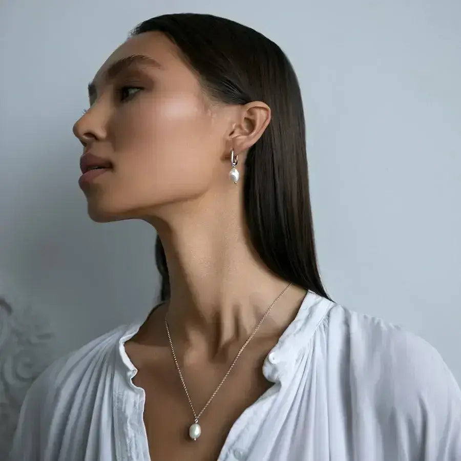 Model showcasing the Lumera Pearl Set with sterling silver and white gold plated necklace and earrings.