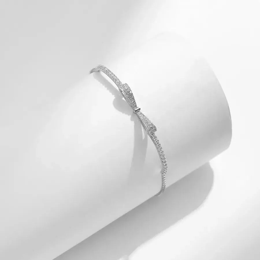 Elegant sterling silver bow knot bracelet with zircon stones, featured on a minimalistic white background.