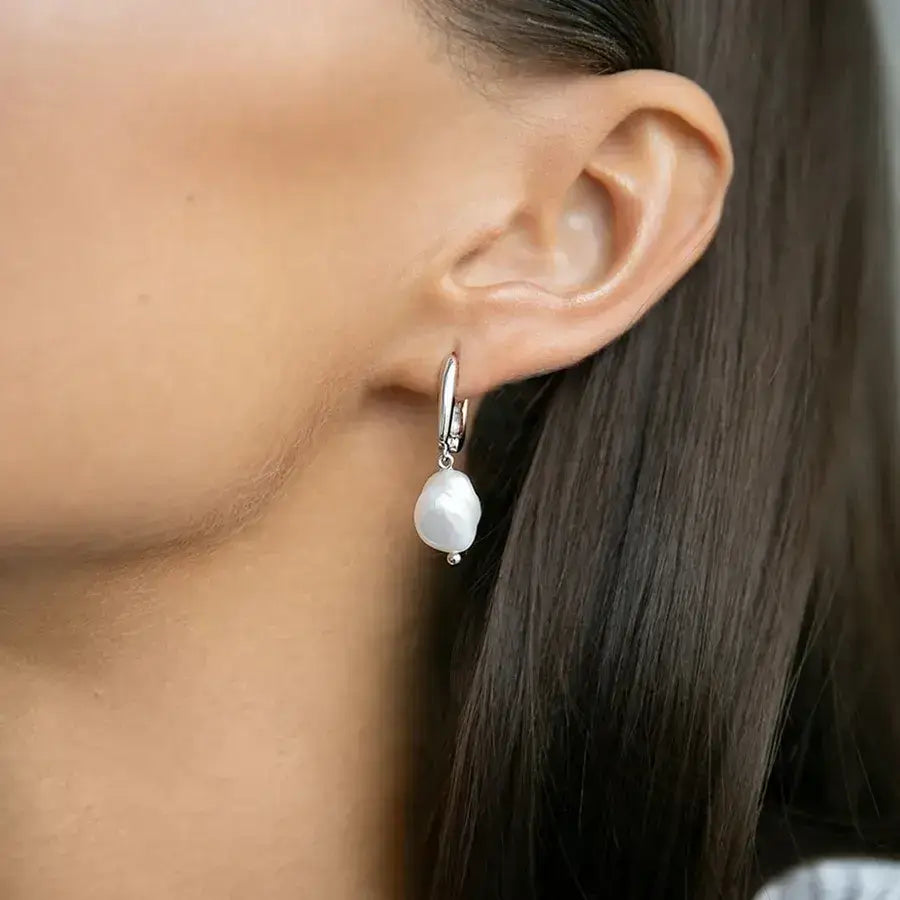 Close-up of a woman wearing pearl earrings from the Lumera Pearl Set, showcasing elegance and craftsmanship.