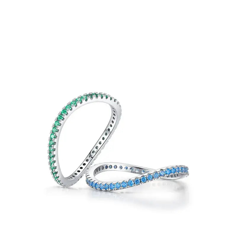 Emerald Glow Eternity Band in Silver alongside a blue zircon eternity band, showcasing vibrant green and blue stones.