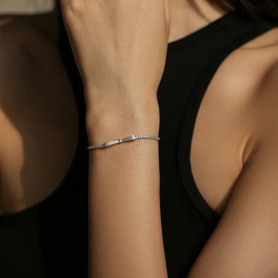 Woman wearing a Bow Knot Bracelet in Sterling Silver adorned with zircon stones, showcasing its elegance and adjustable fit.