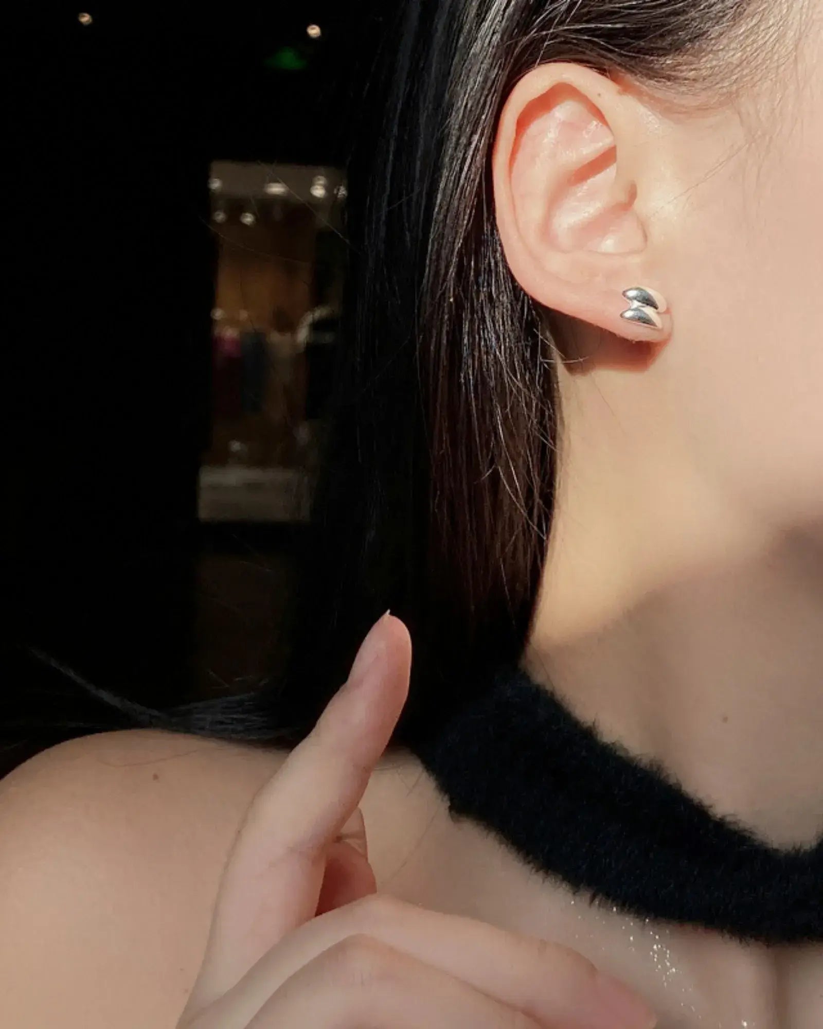 Close-up of a woman wearing Sculptura Ear Studs made of 925 sterling silver in a modern geometric design.