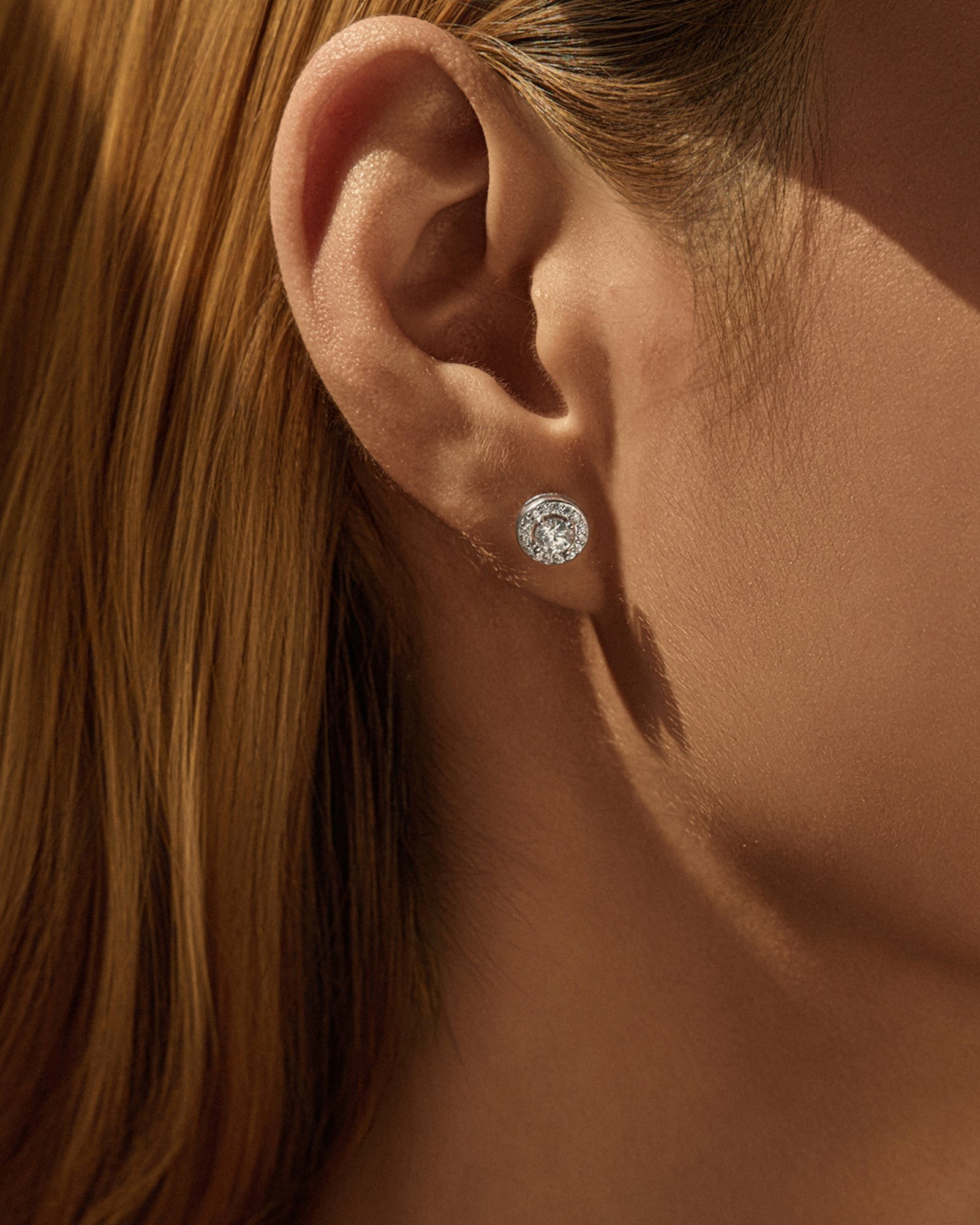 Close-up of a Round Brilliant Cut moissanite Stud worn in the ear, showcasing its exceptional sparkle and brilliance.