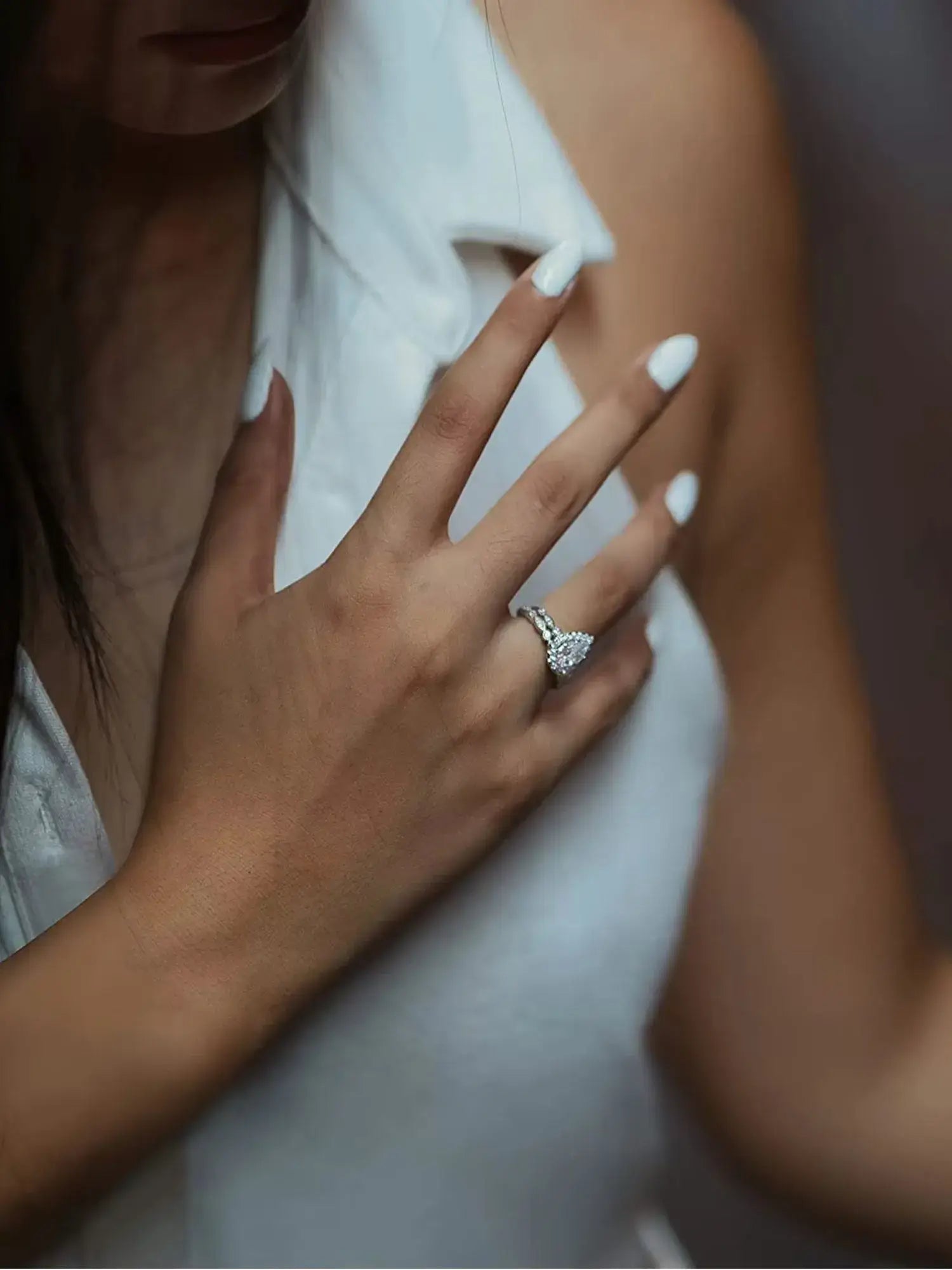 Elegant hand displaying a 1.5CT teardrop CZ ring in a romantic setting, perfect for engagements or gifts.