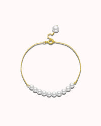 Pearl bracelet with gold clasp on a white background