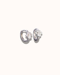 Pair of silver earrings with floral designs on a white background