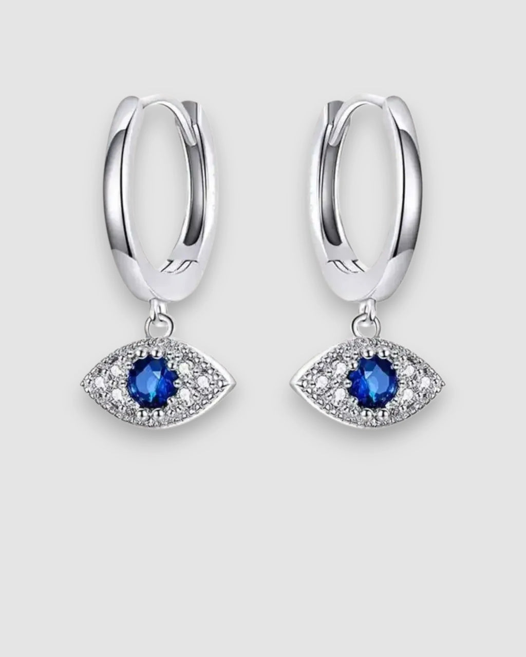 Silver hoop earrings with blue gemstone eye designs on a light gray background