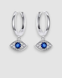 Silver hoop earrings with blue gemstone eye designs on a light gray background