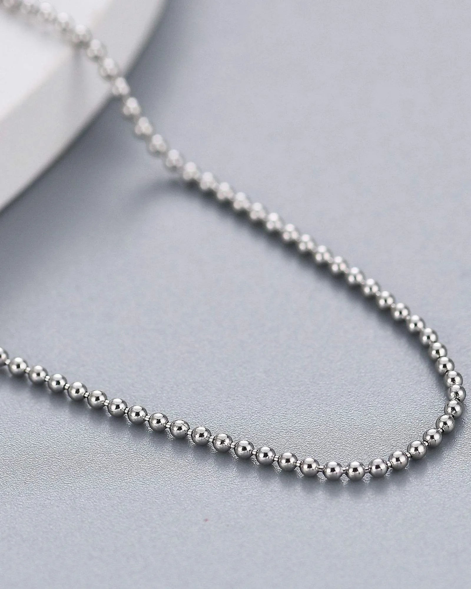 2mm ball bead chain in sterling silver with a sleek, mirror-like finish on a gray background.