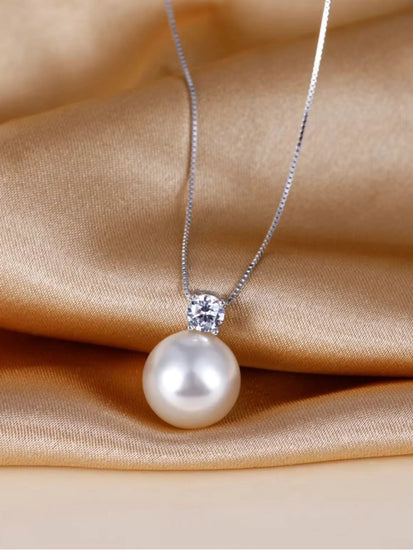 Maris Pearl Necklace featuring a AAA-grade pearl and zirconia on a silver chain, elegantly displayed on satin fabric.