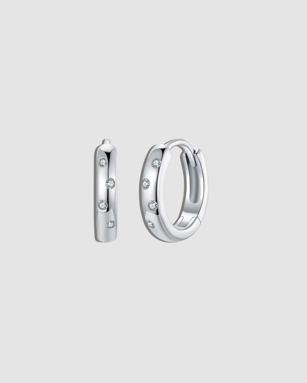 Silver hoop earrings with small stones on a white background